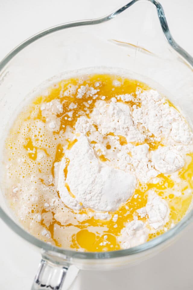 Wet and dry ingredients combined in a glass mixing bowl.