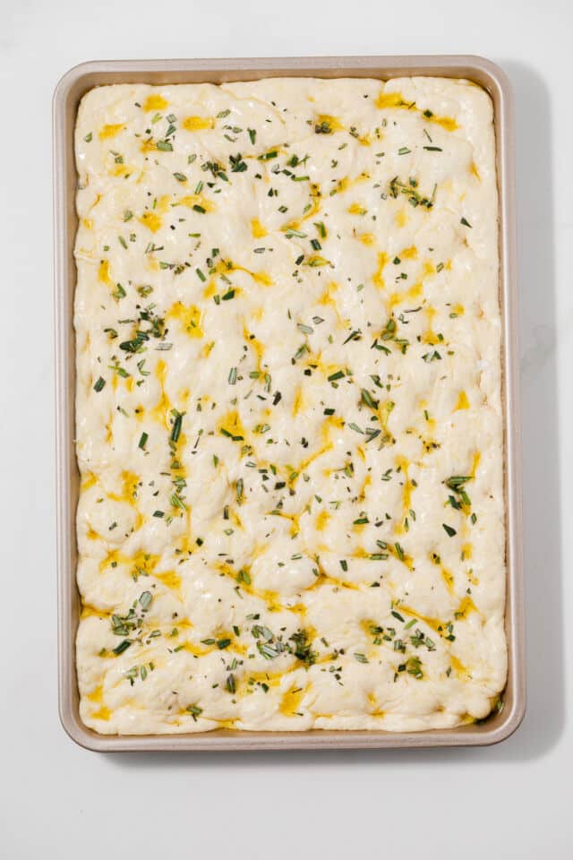 Dough topped with olive oil, salt, and rosemary.