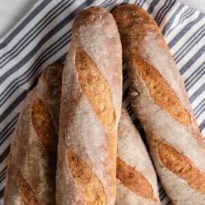 overhead of baguettes on a blue and white striped napkin