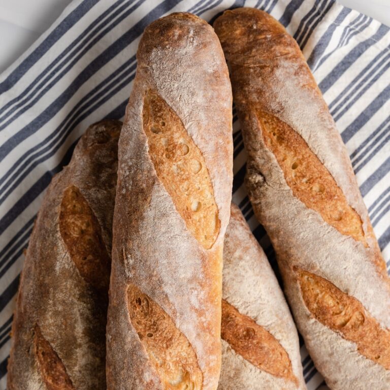 overhead of baguettes on a blue and white striped napkin