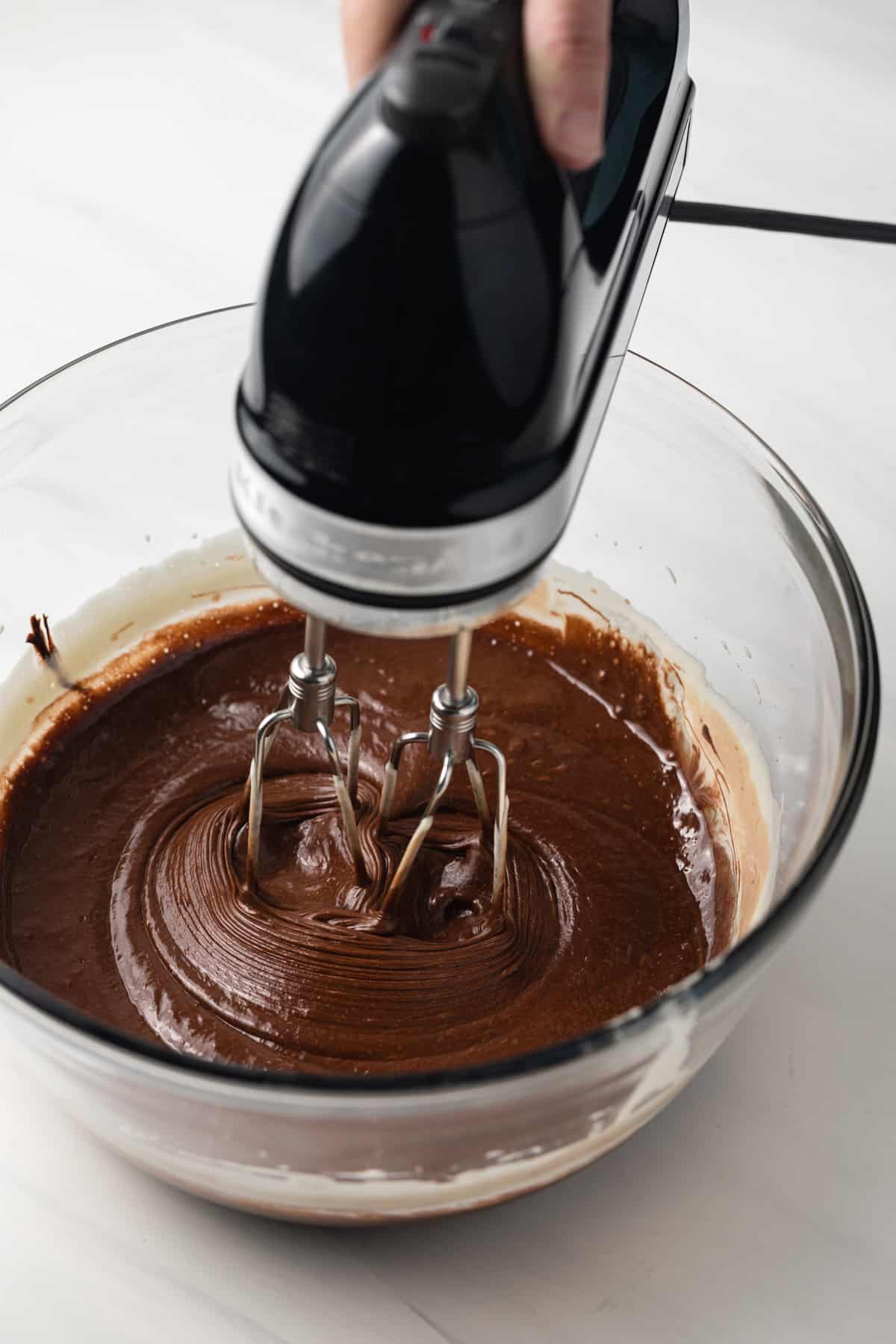 Beating in chocolate with eggs and sugar.