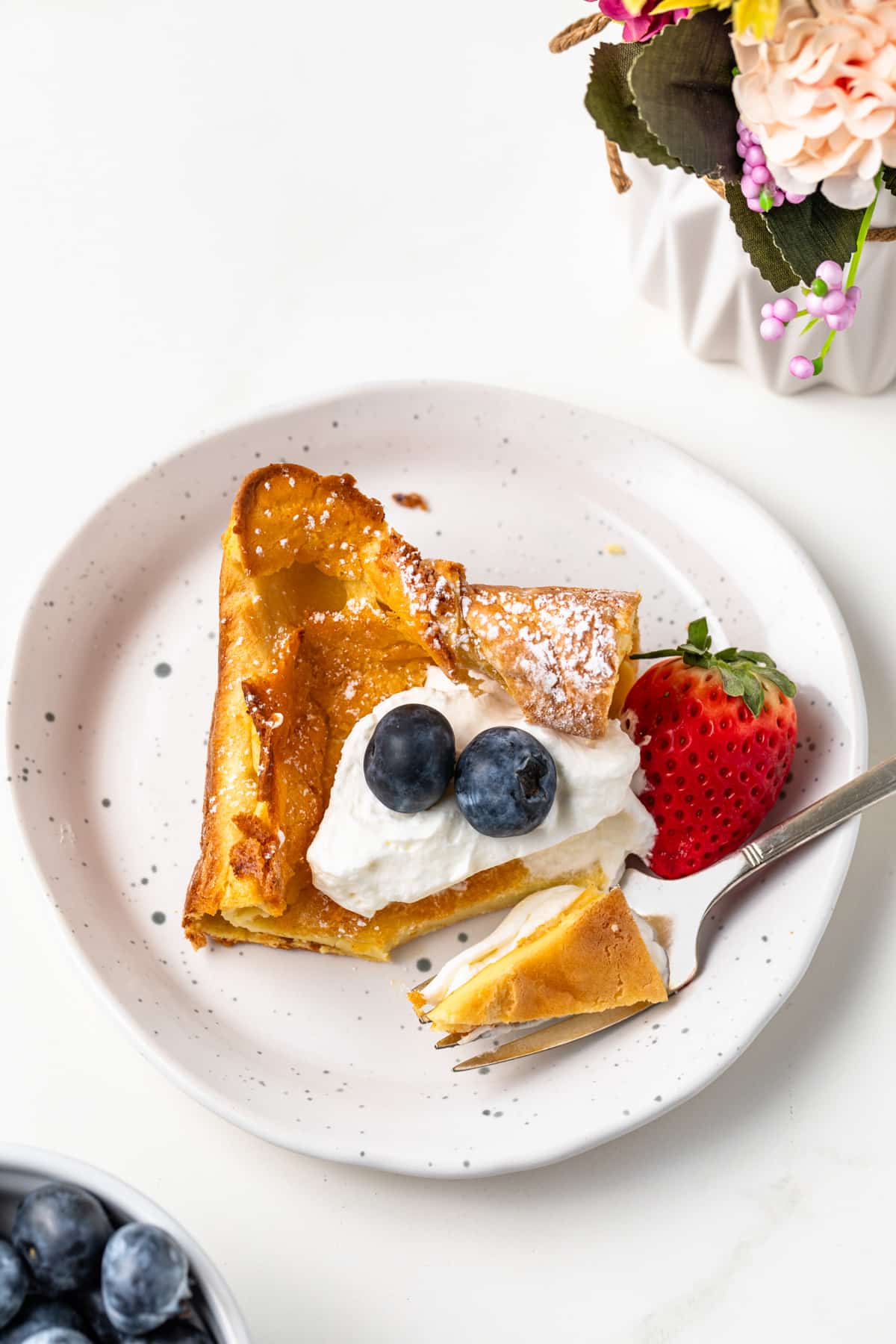 Fork taking a bite out of a German pancake.
