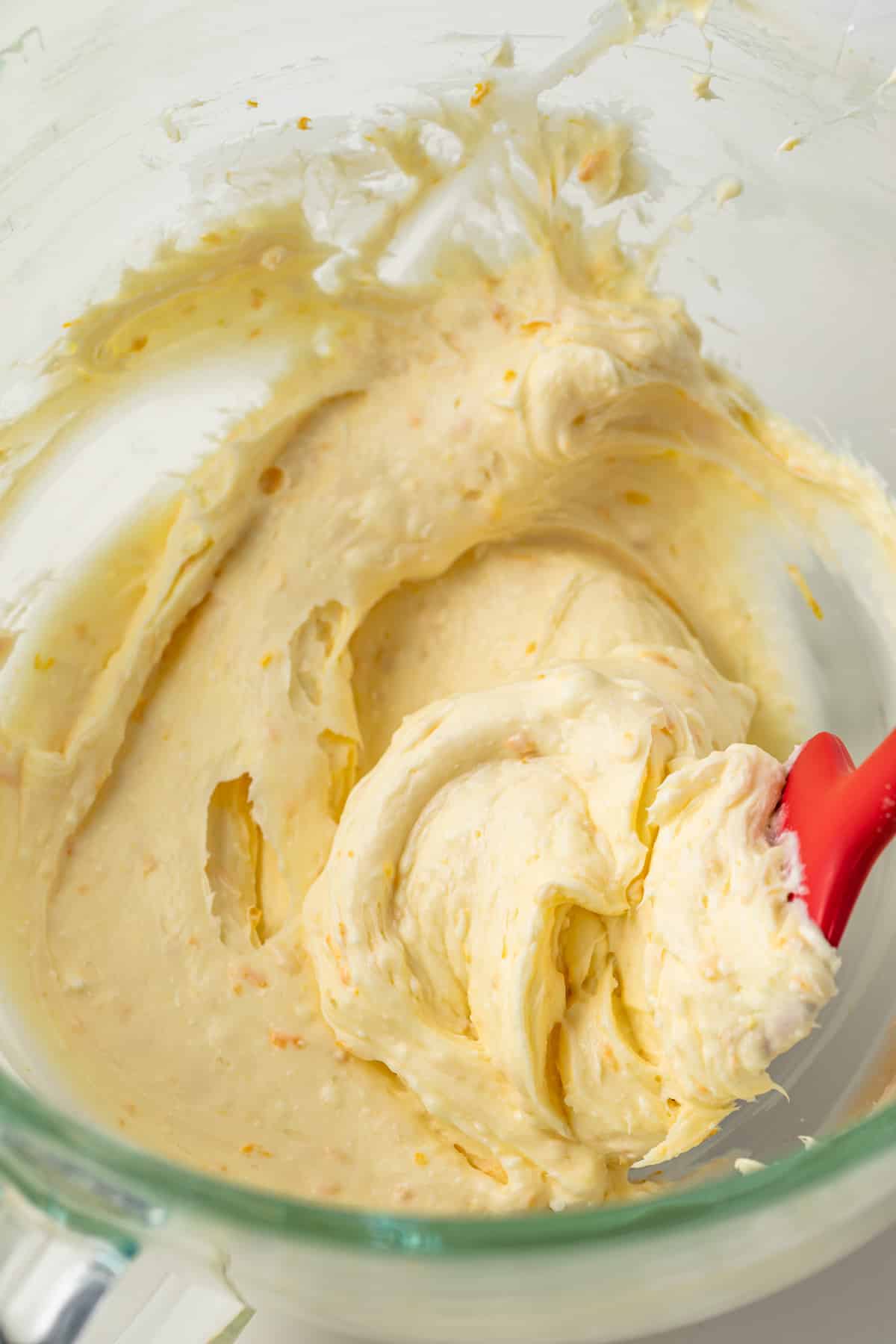 Orange mascarpone frosting in a glass bowl.