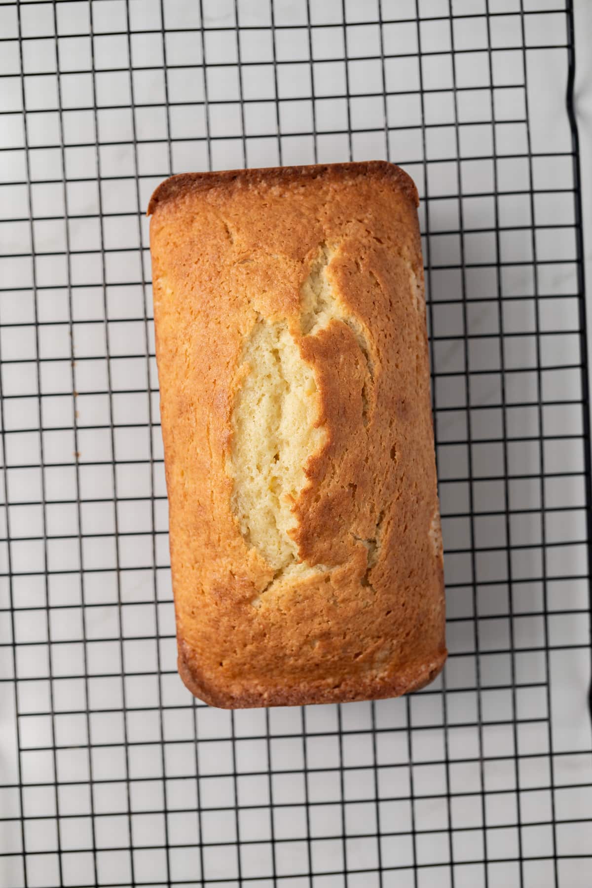 Baked lemon loaf on wire rack.