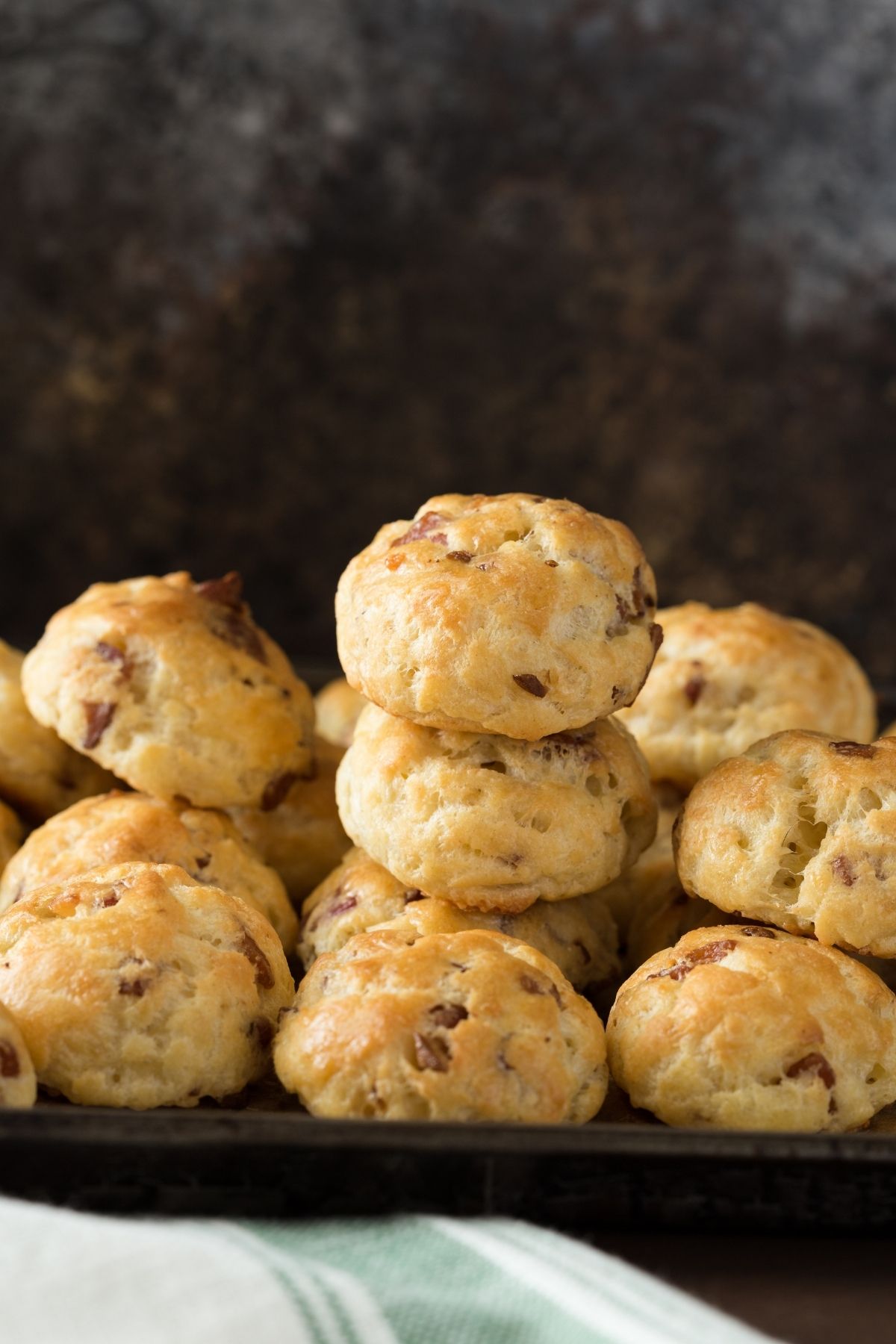 Bacon Garlic Gougères stacked on a baking sheet.