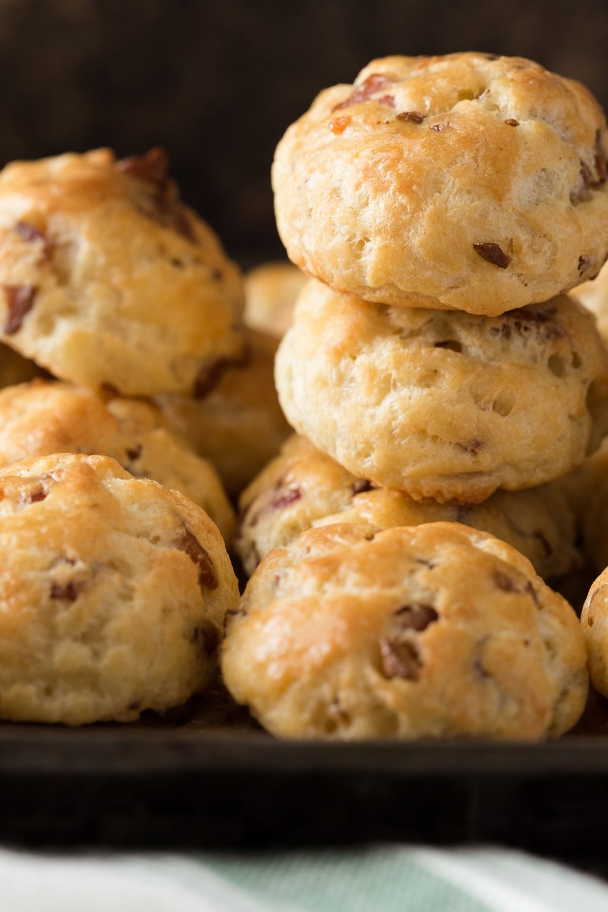Front close up view of Bacon Garlic Gougères stacked on a baking sheet.