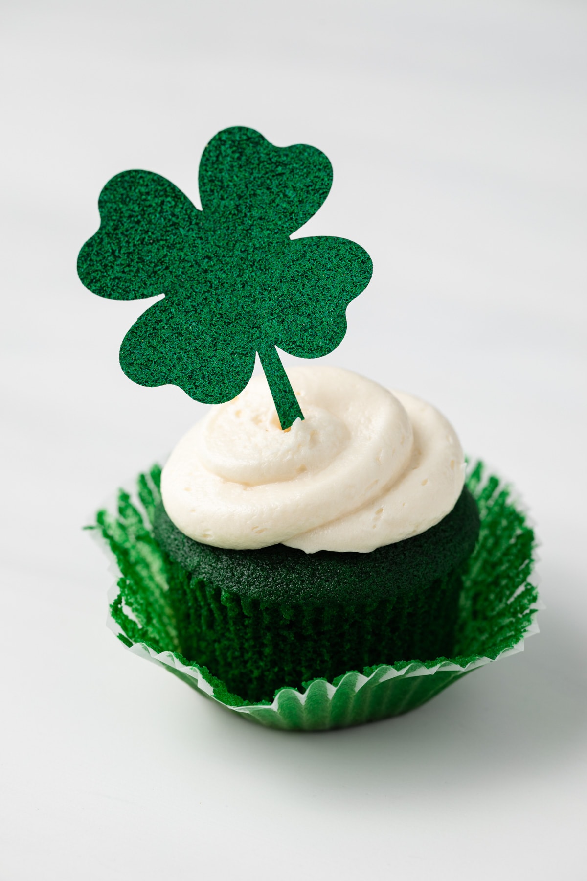 Green velvet cupcake with shamrock topper.