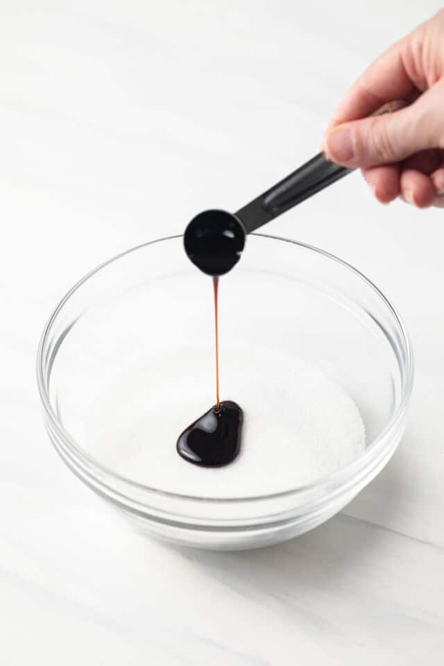 Molasses being poured into white sugar.