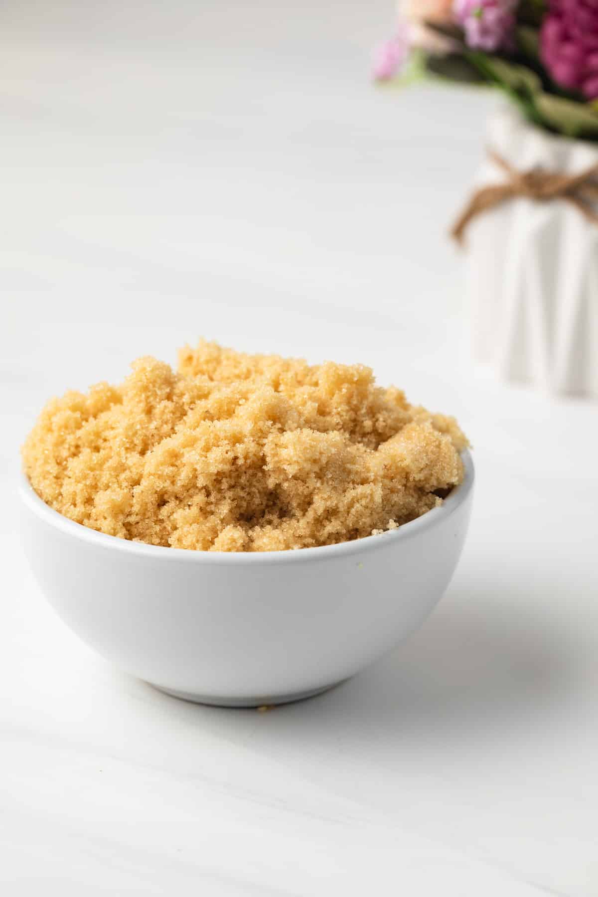 Angled view of homemade brown sugar in white bowl.