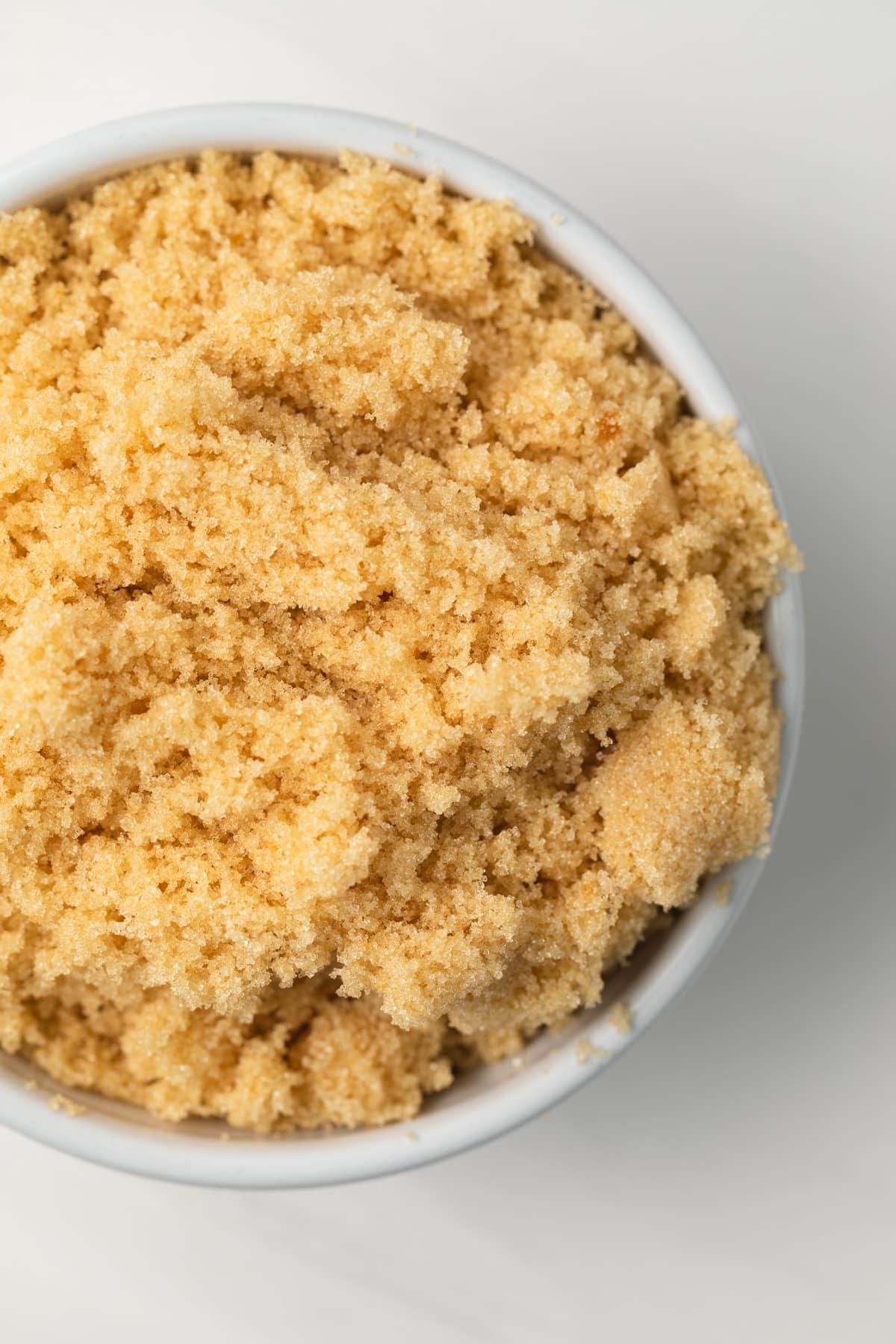 Overhead of brown sugar in a white bowl.