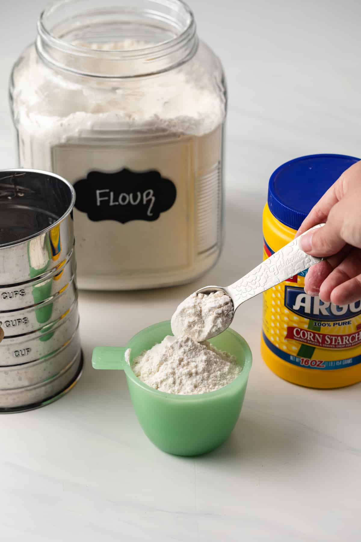 Flour being added to measuring cup.