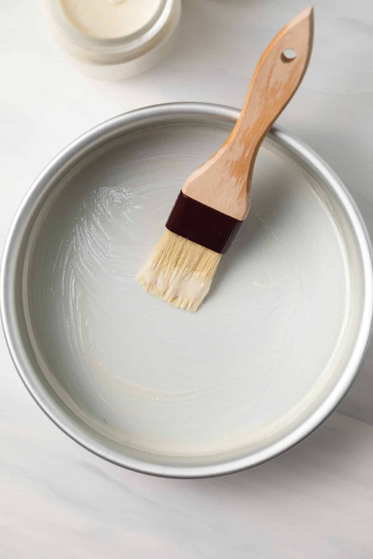 Cake release spread in a cake pan with pastry brush.