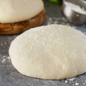 side view of pizza dough on a gray background