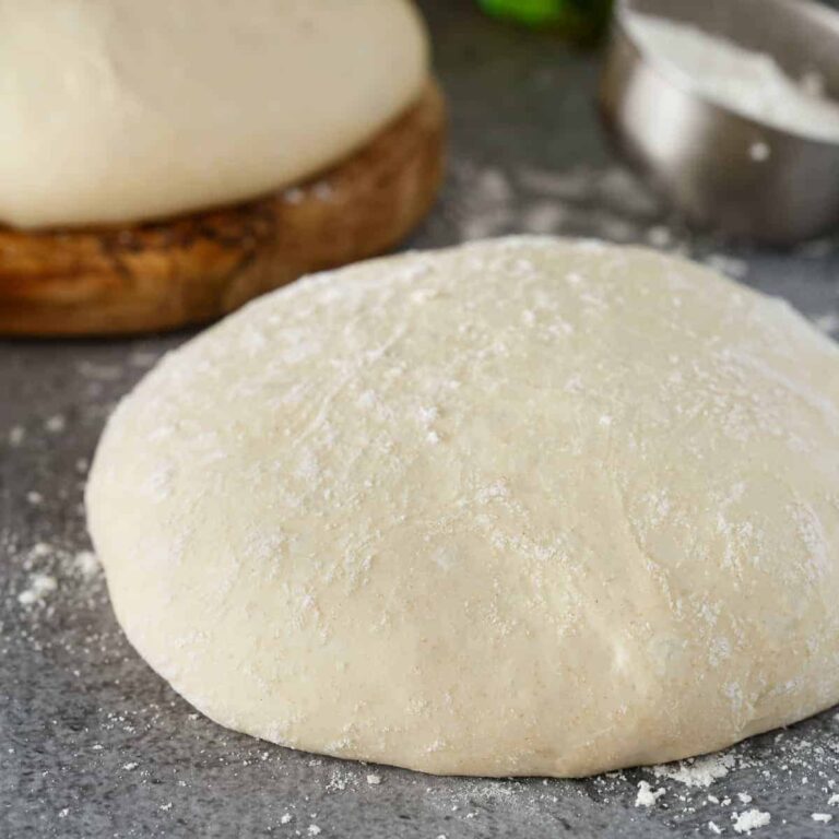 side view of pizza dough on a gray background