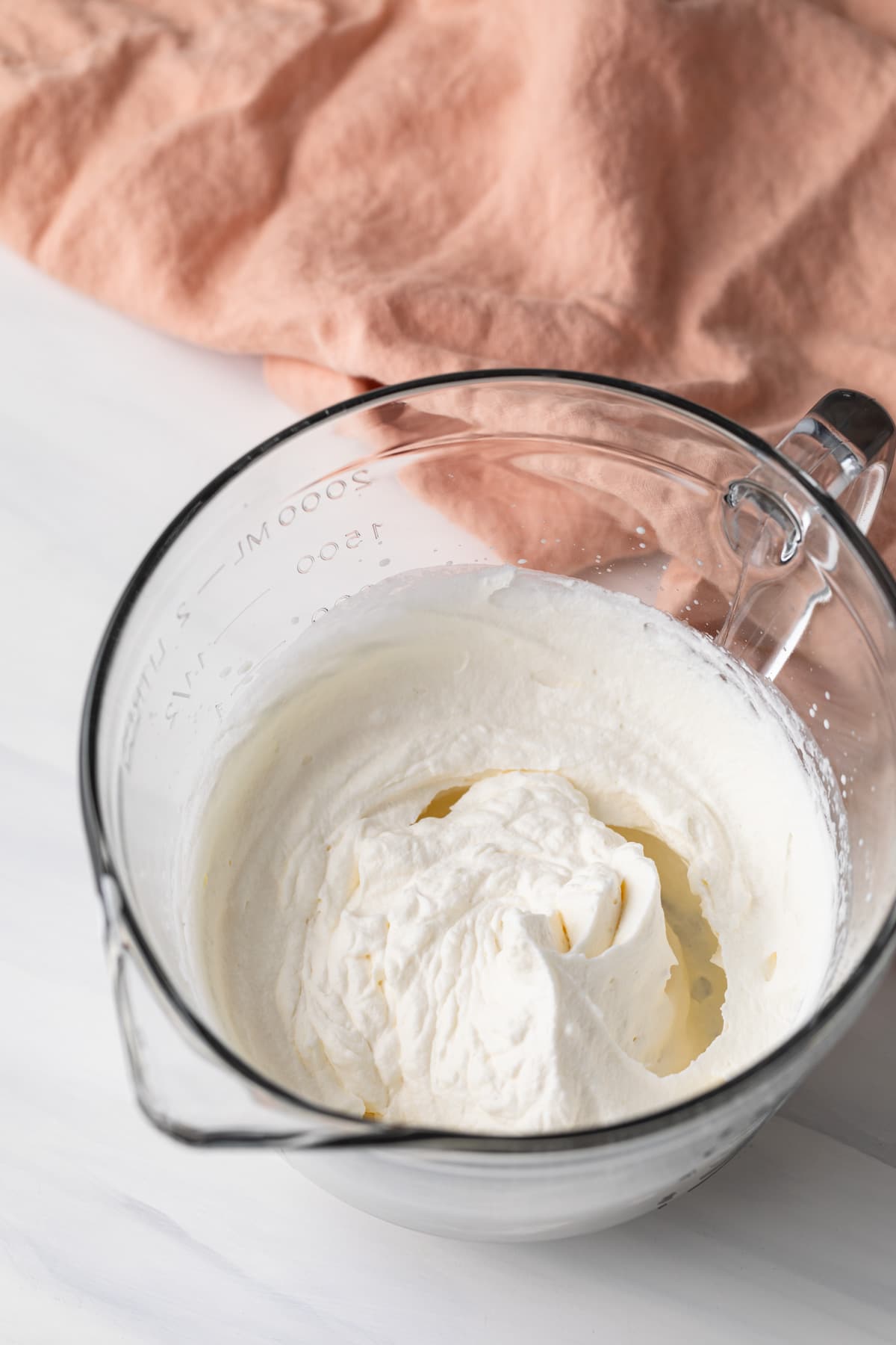 homemade whipped cream in glass mixing bowl