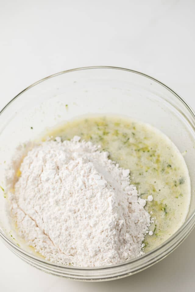 Wet and dry ingredients combined in glass bowl.