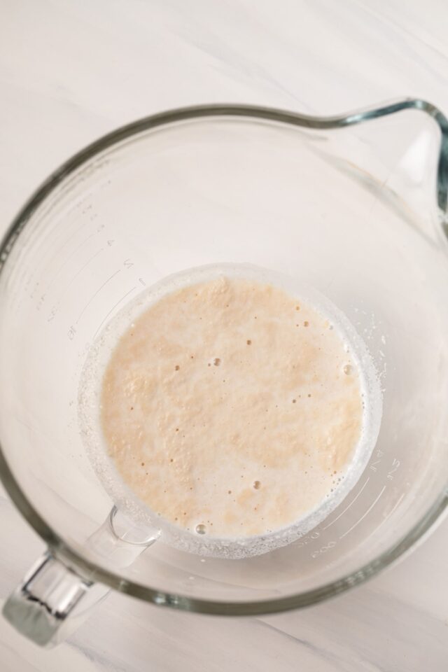 Milk and foamy yeast in glass bowl.
