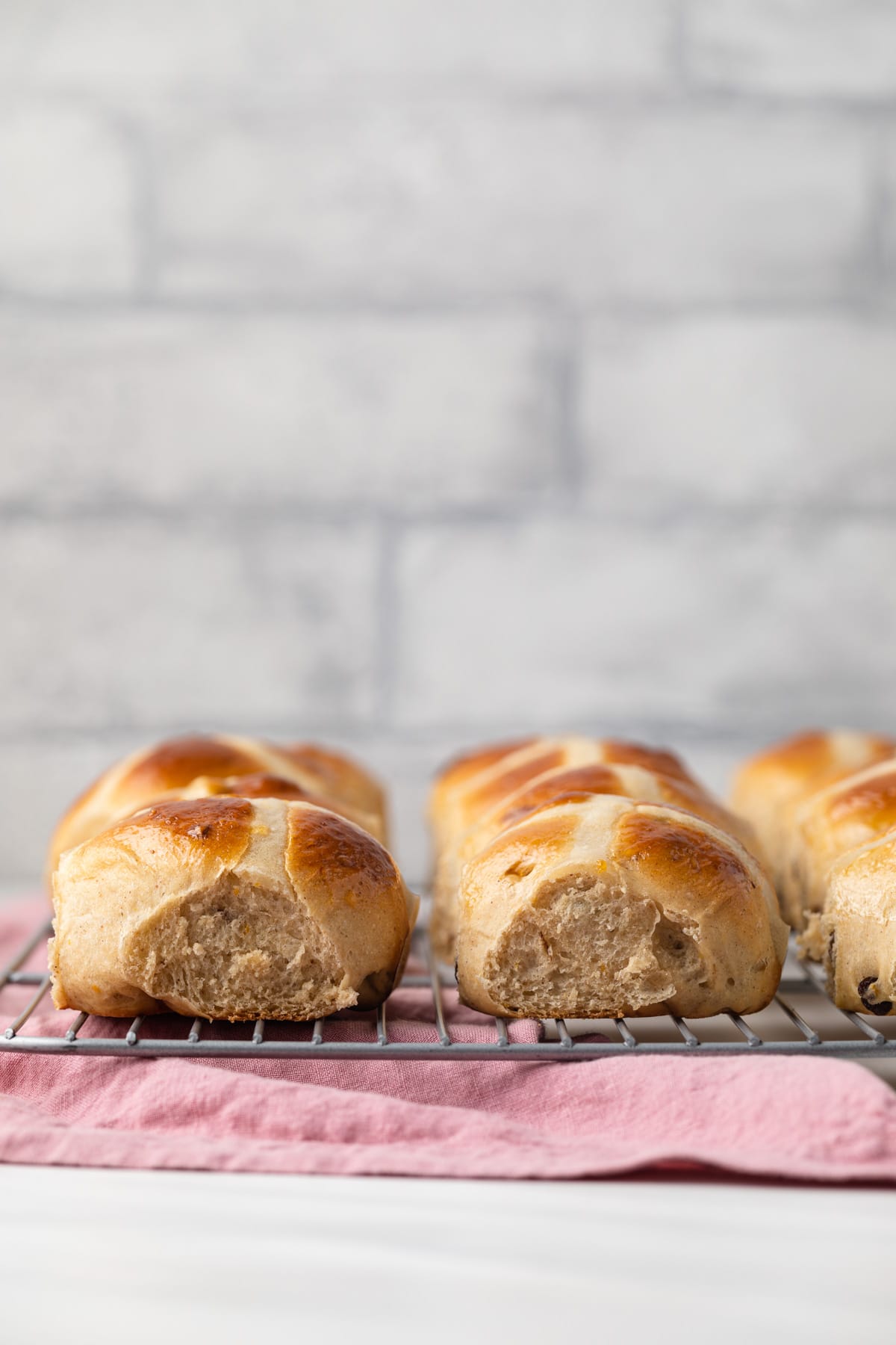 Side view of hot cross buns on wire rack.