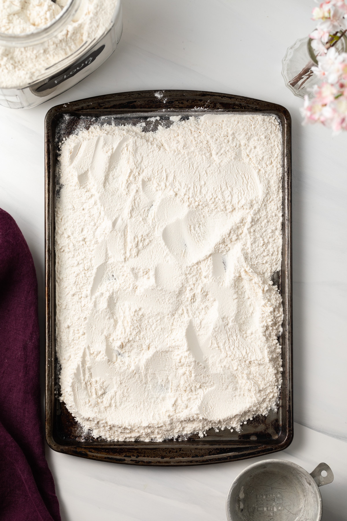 Raw flour on a rimmed baking sheet.