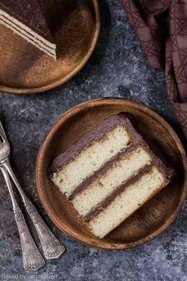 Close up overhead view of a slice of vanilla cake with chocolate frosting.