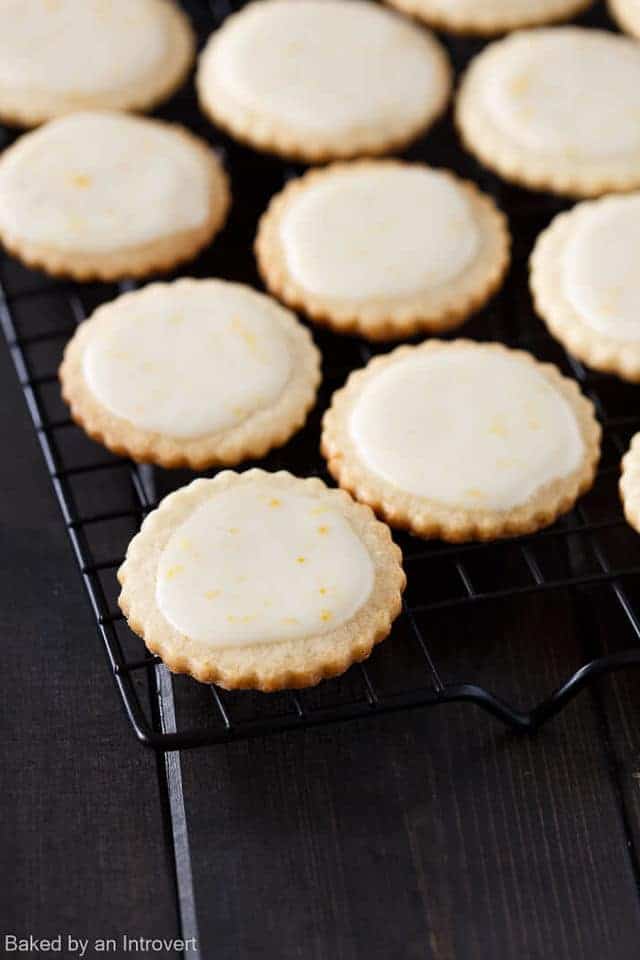iced Meyer lemon cookies on a black wire rack