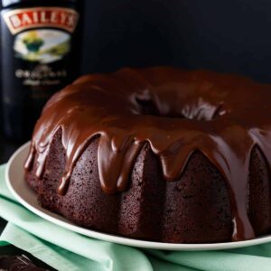 Side view of Irish chocolate coffee bundt cake on a cream plate set over a green napkin.