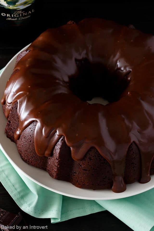 Overhead view of Irish chocolate coffee bundt cake on a cream plate set over a green napkin.