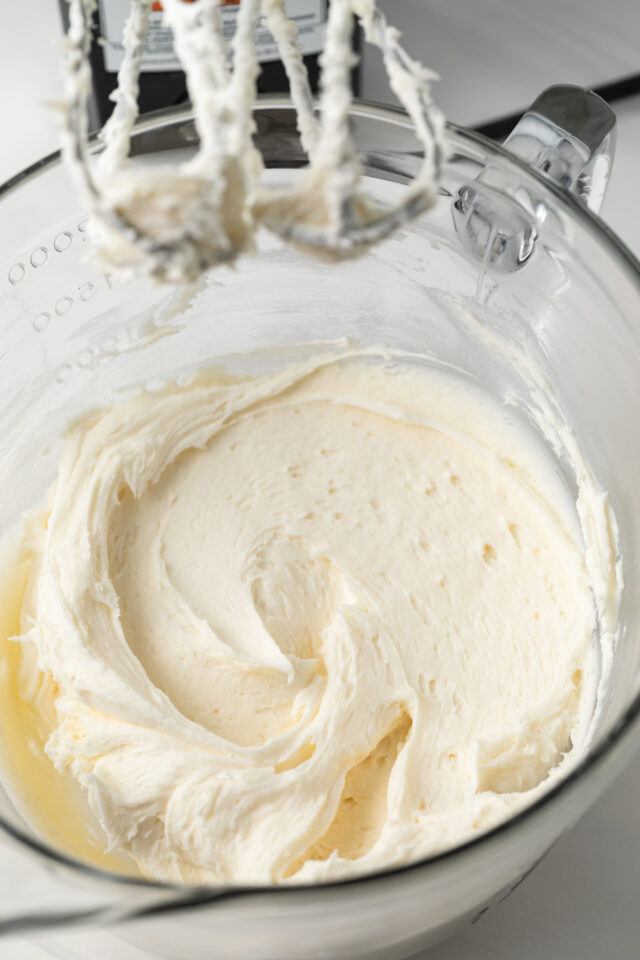 Butter, cream cheese, and powdered sugar creamed in glass bowl.