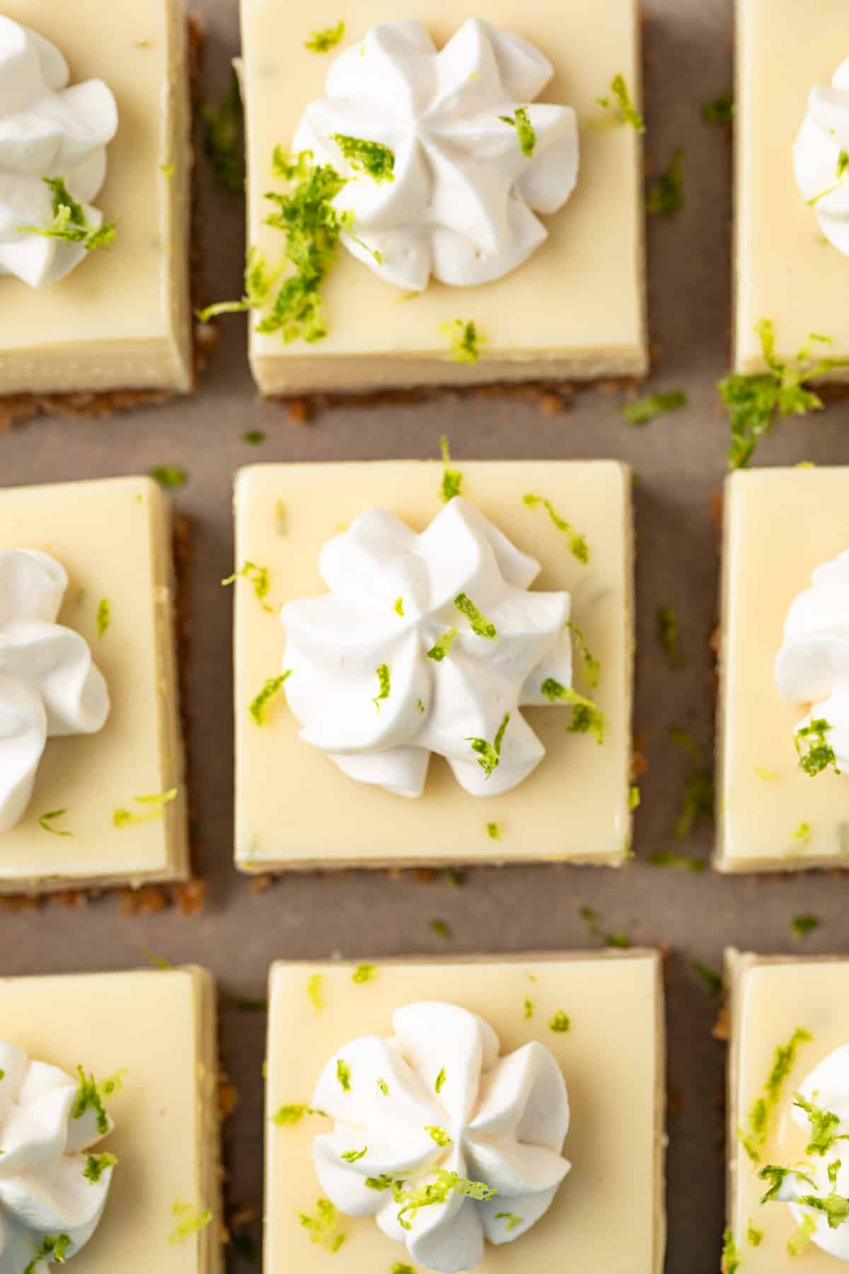 Overhead of key lime bars topped with whipped cream.