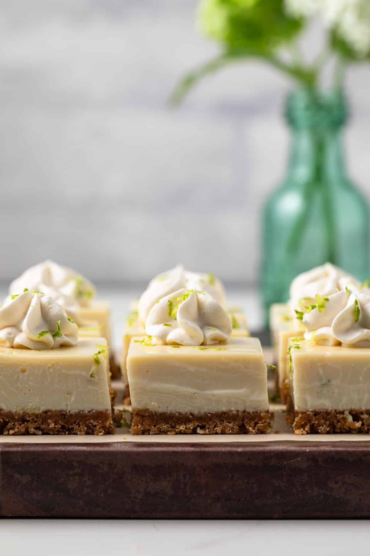 Key lime bars on a wooden platter.