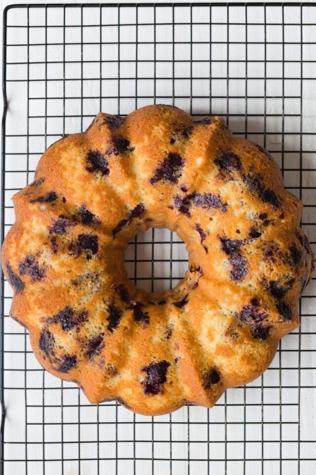 Lemon blueberry bundt cake on wire rack.