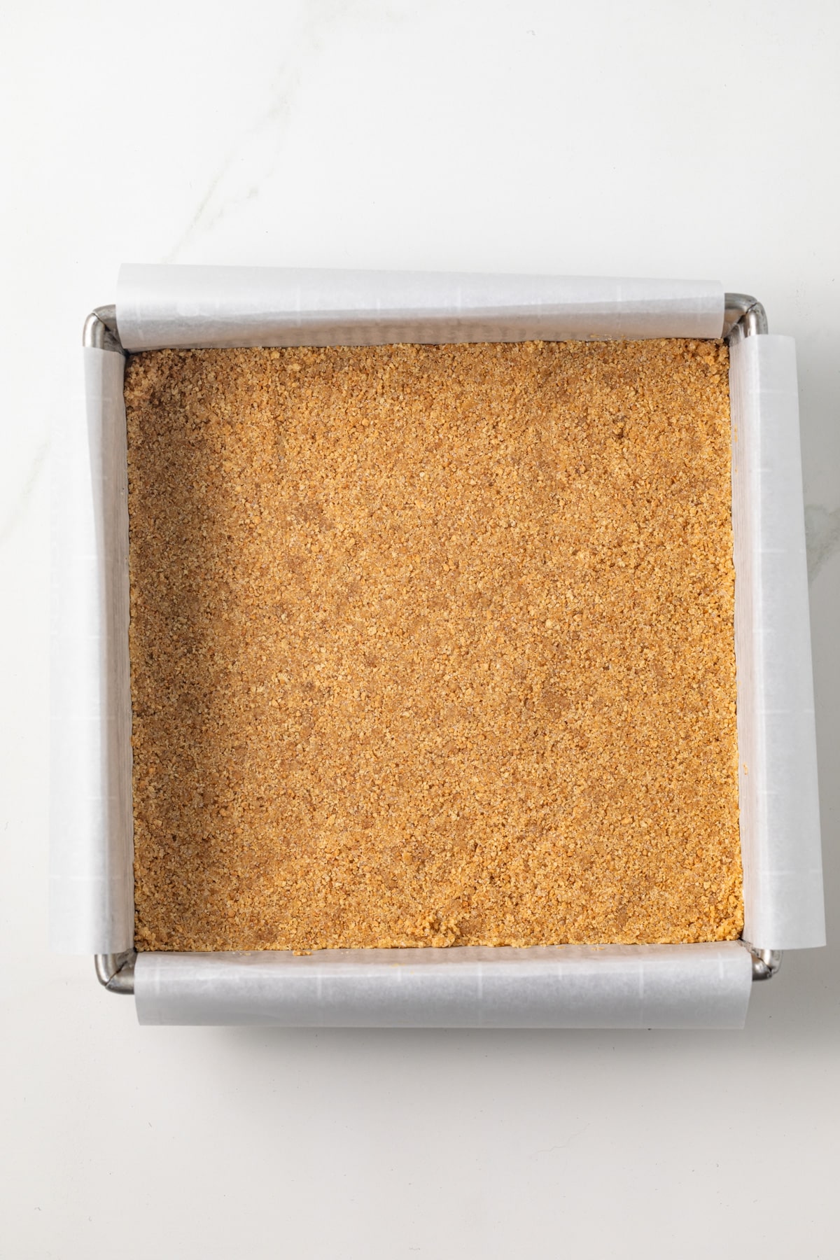 Graham cracker crumbs pressed into a baking pan.