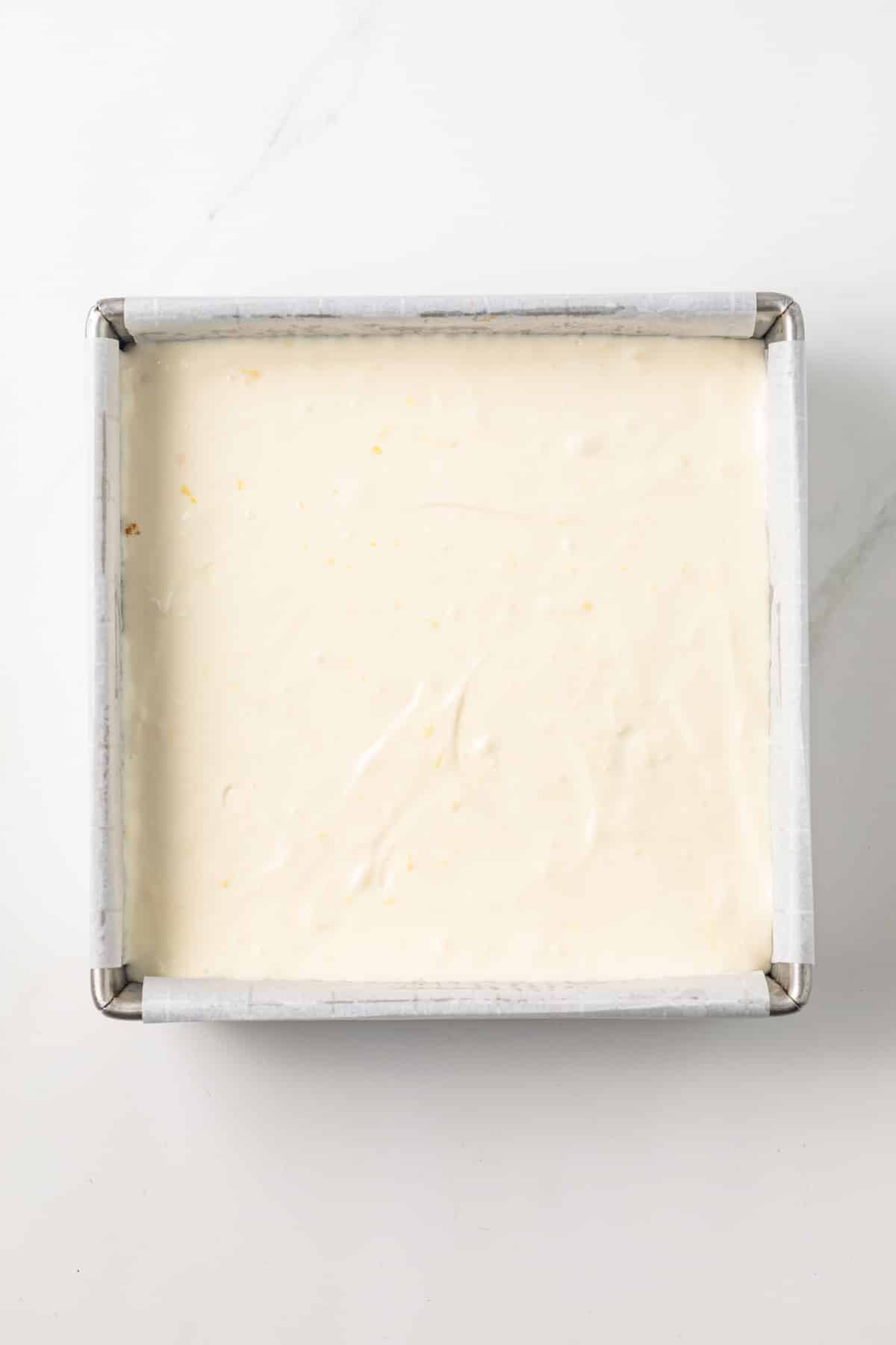 Lemon cheesecake in a square baking pan.