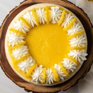 Overhead of lemon cheesecake on wooden stand.