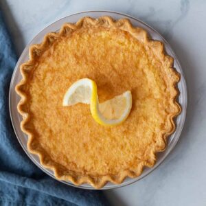 Overhead view of lemon chess pie with a lemon slice on top.