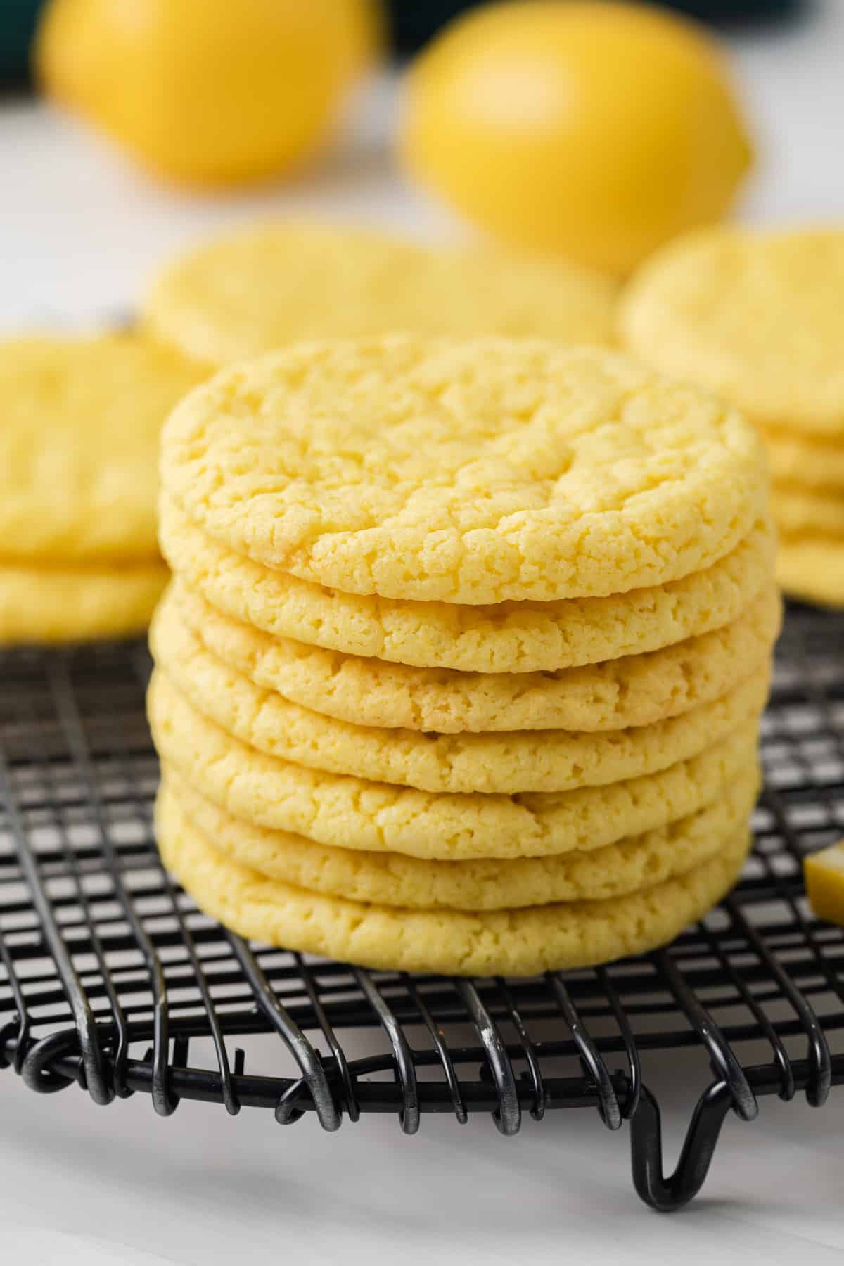 Close up of lemon cookies stacked on wire rack.