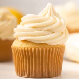 Close up of lemon cream cheese frosting swirled in top of a cupcake.