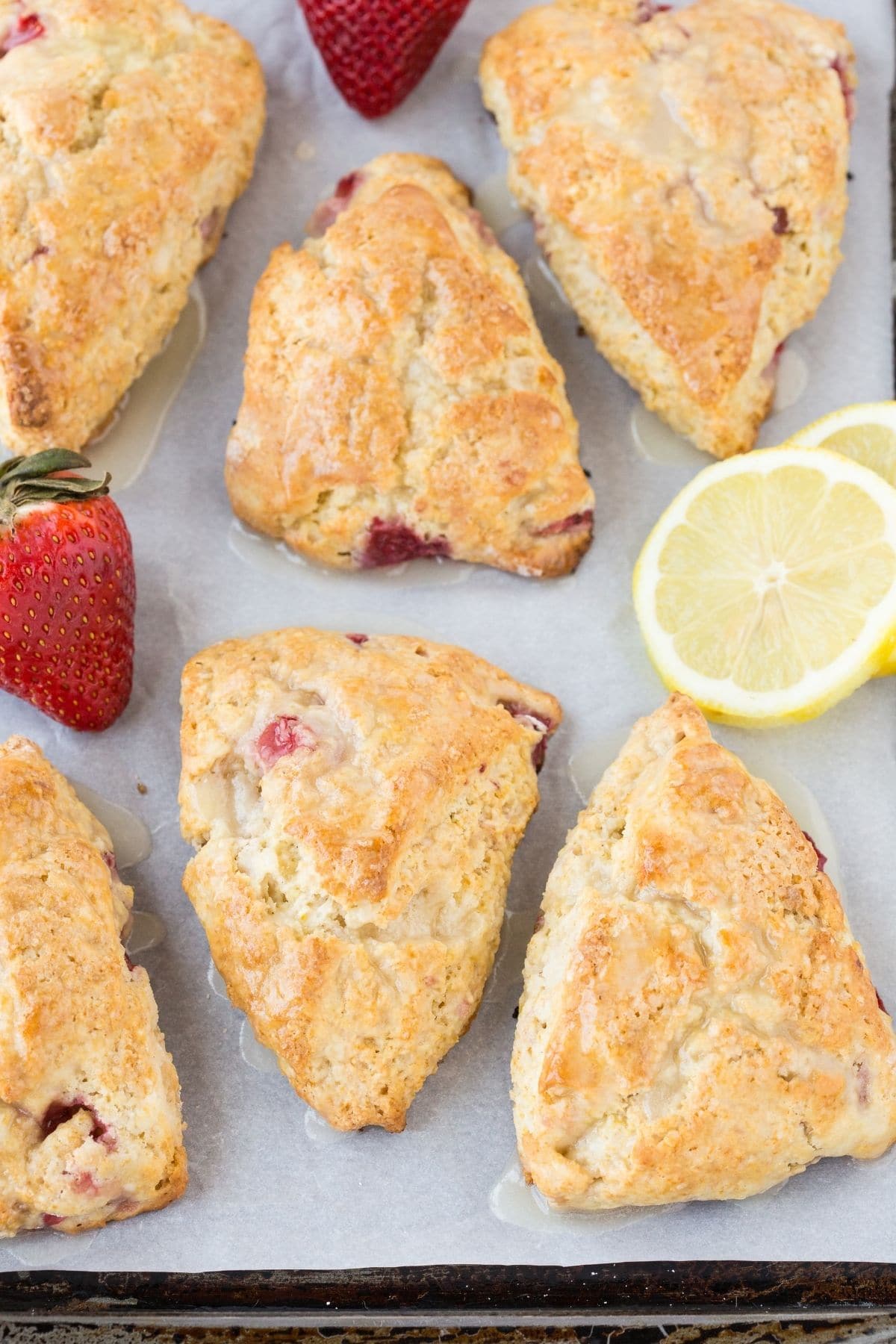 Overhead view of Lemon Cream Cheese Scones filled with fresh strawberries on a baking sheet.