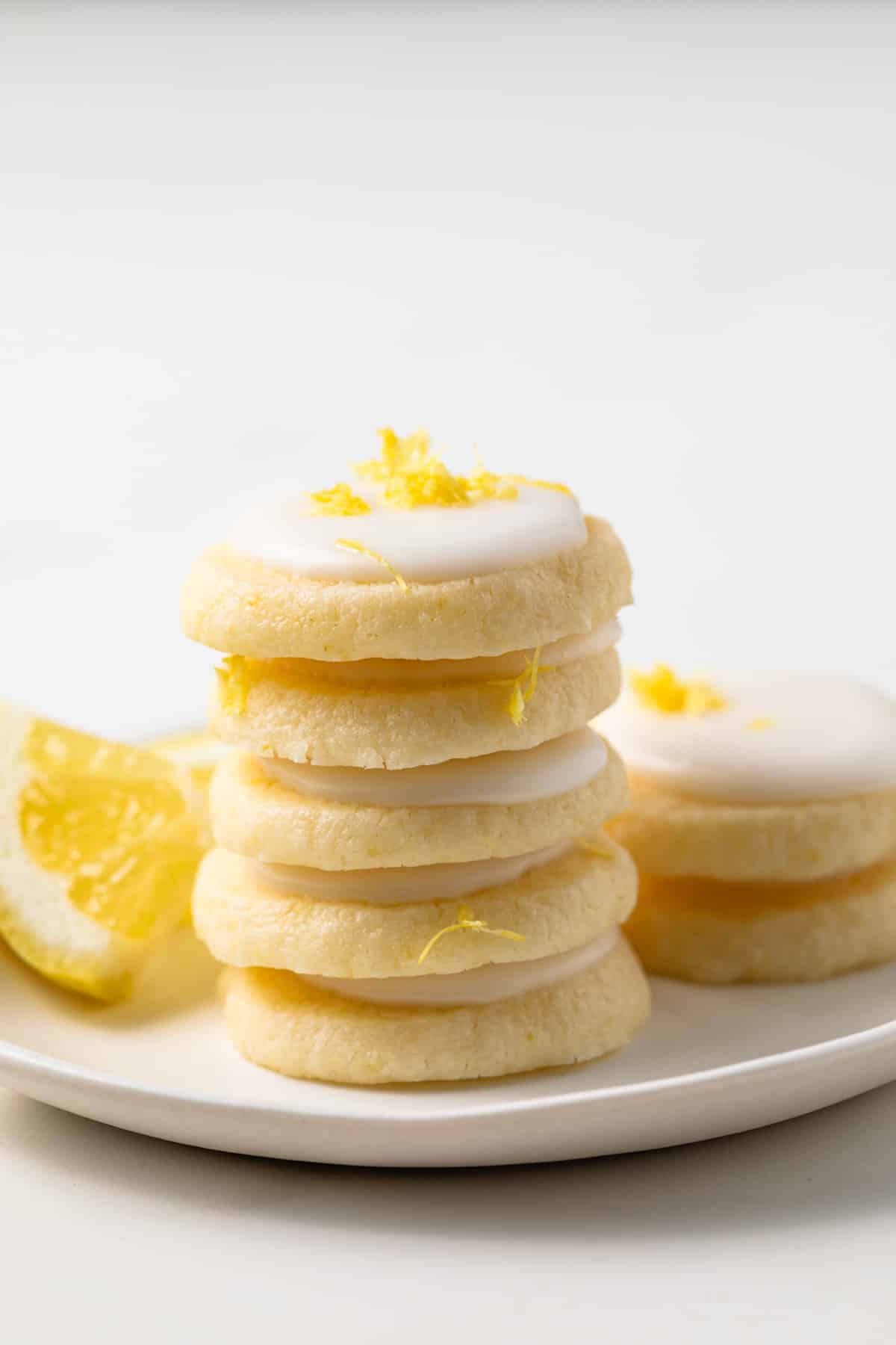Lemon meltaway cookies stacked on a white plate.