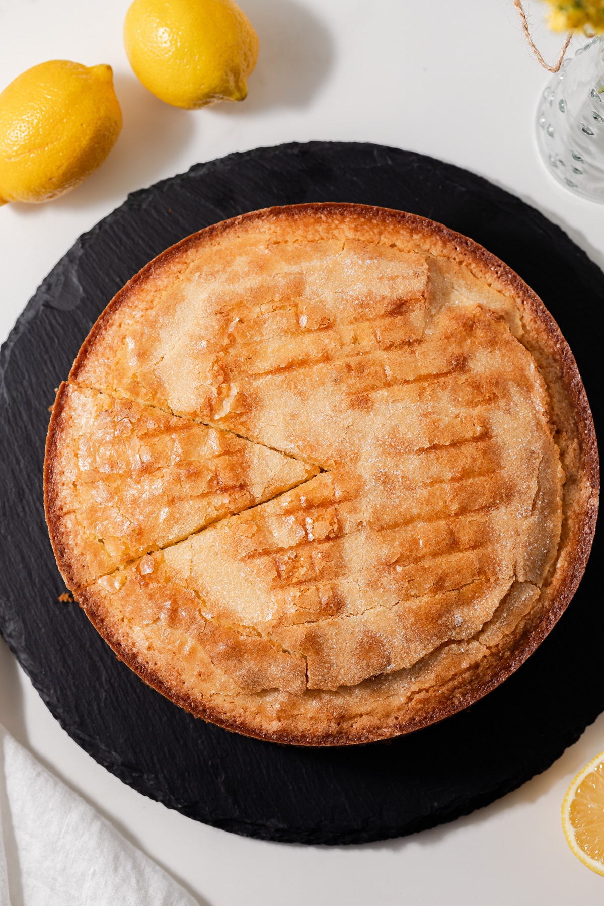 Overhead view of lemon olive oil cake with a slice cut out.