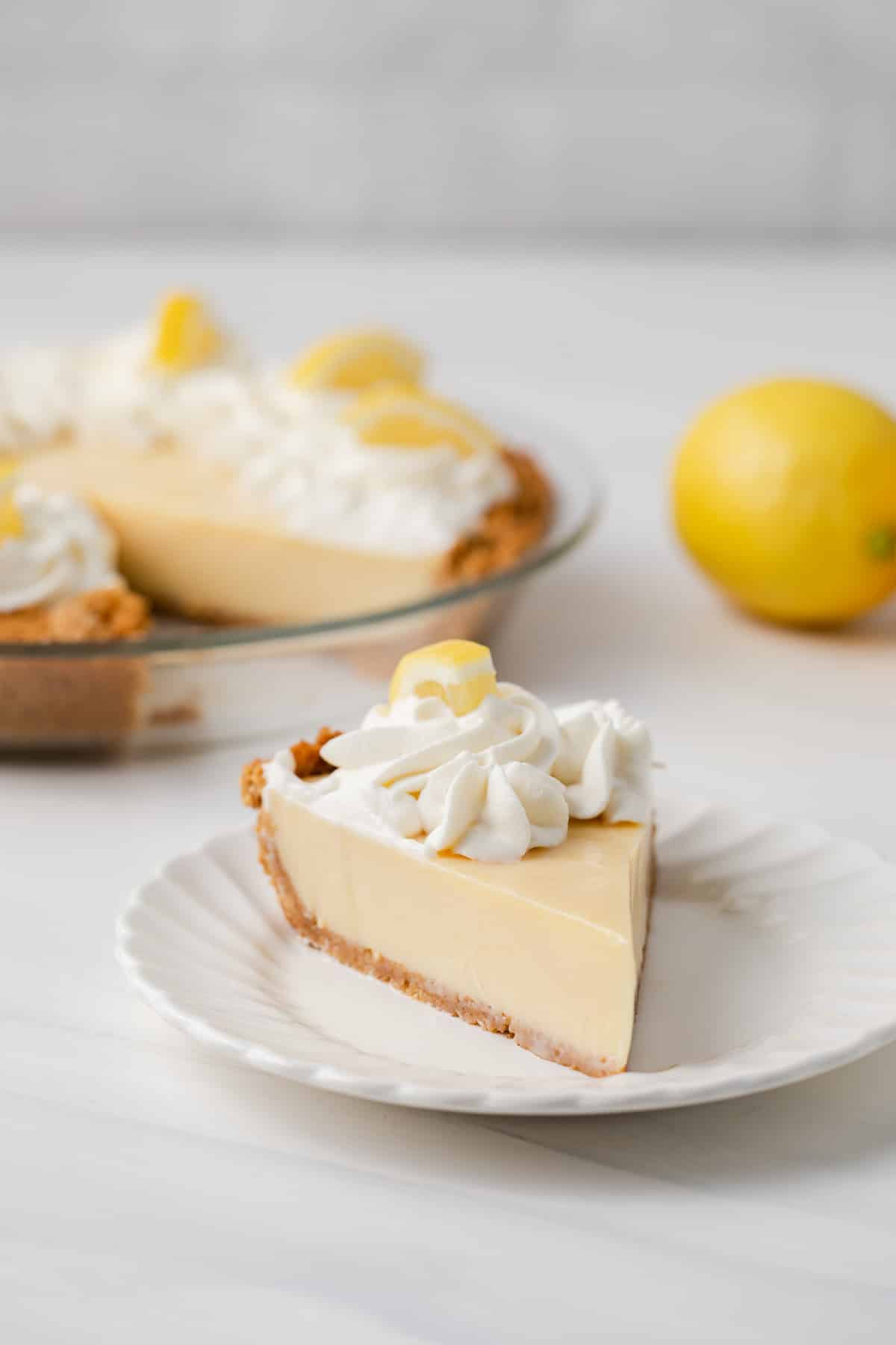 Slice of lemon pie on white plate.