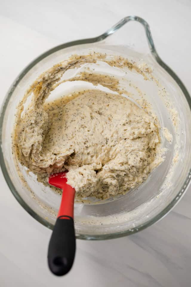 Lemon poppy seed muffin batter in glass bowl.