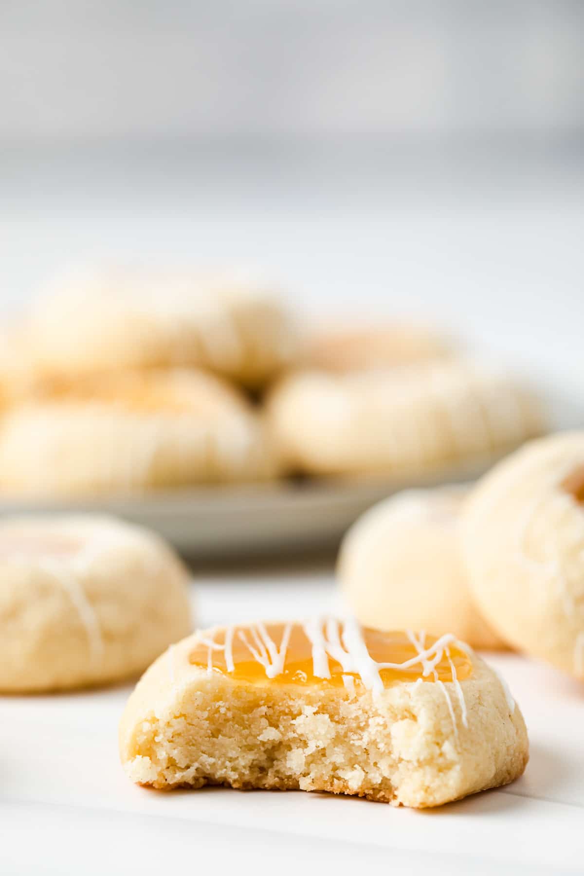bite taken out of lemon curd thumbprint cookies
