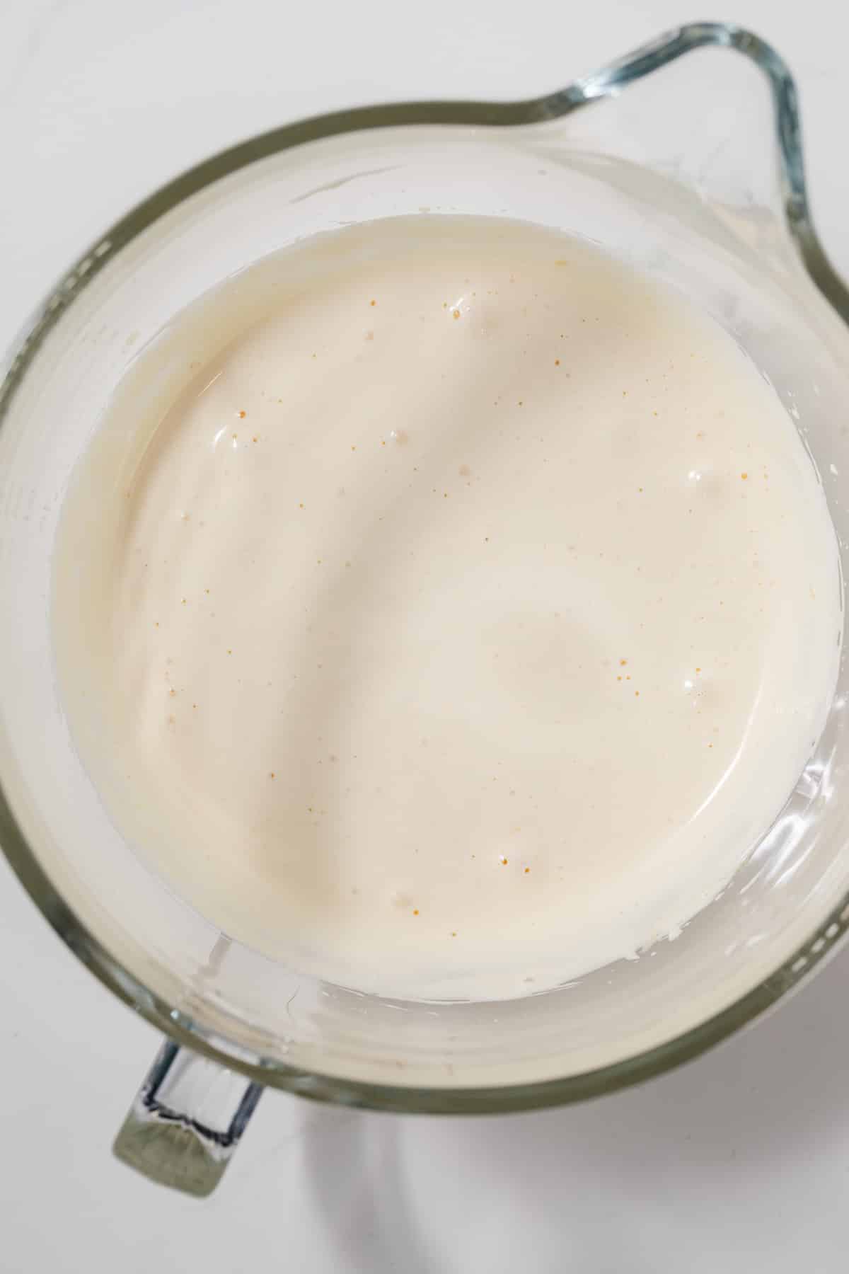 Whipped eggs and sugar in glass bowl.