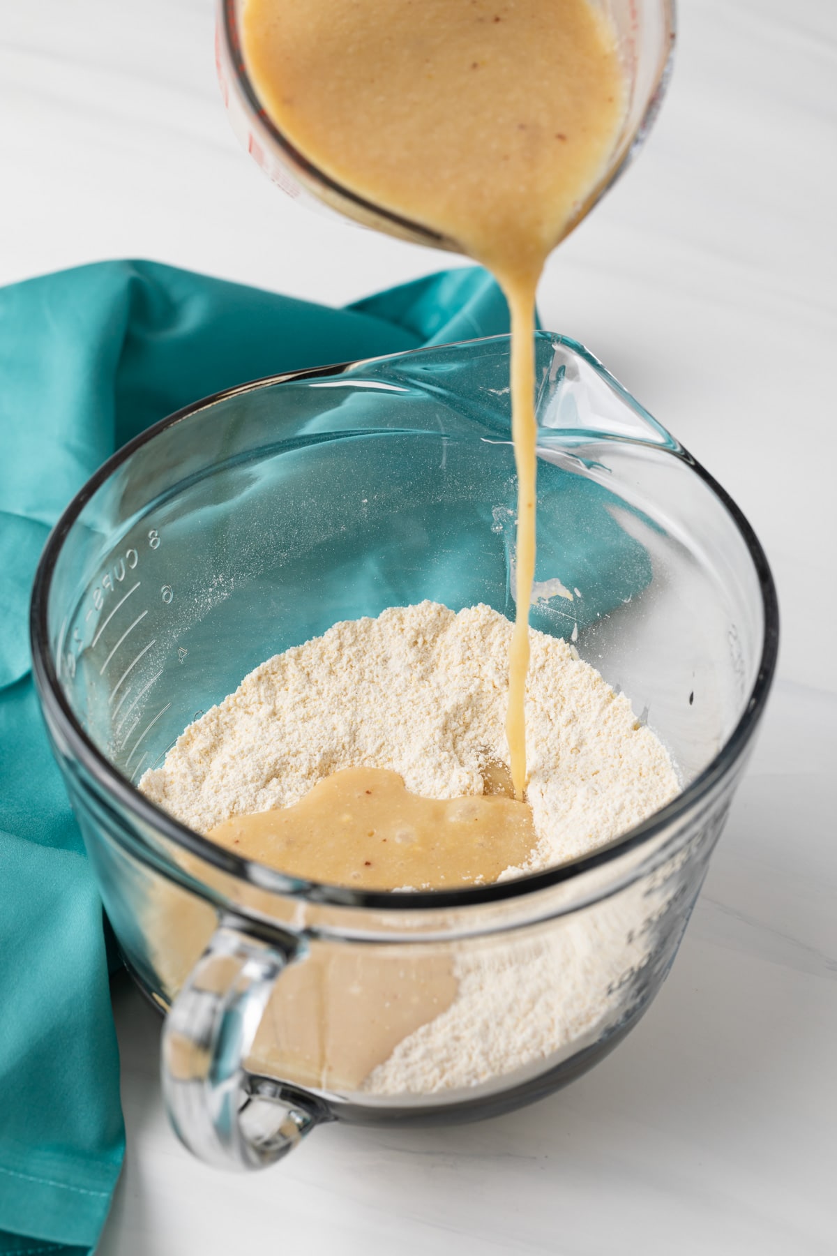 wet ingredients being poured into dry ingredients
