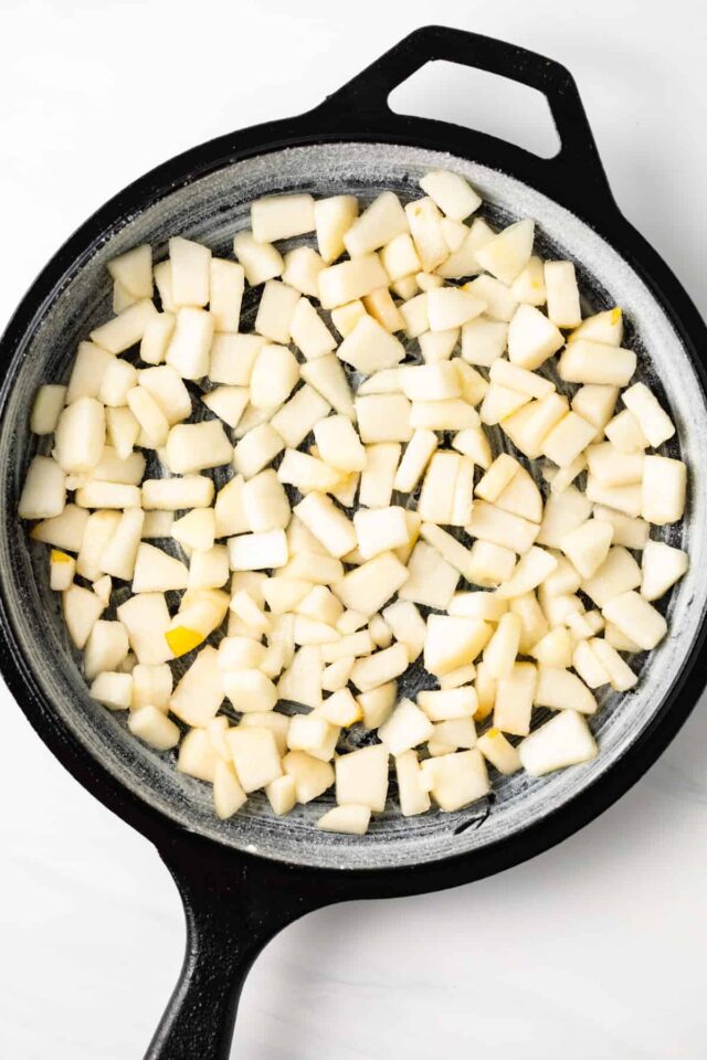 Chopped pears in a greased cast iron skillet