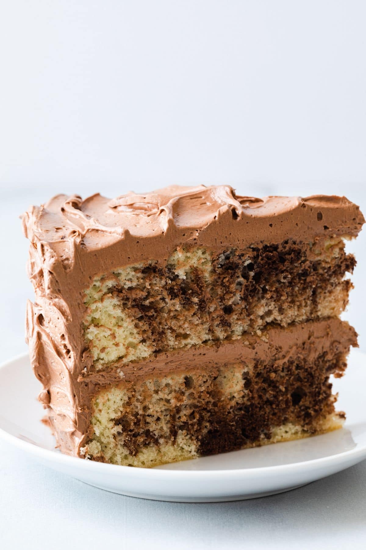 side view of slice of marble cake on white plate