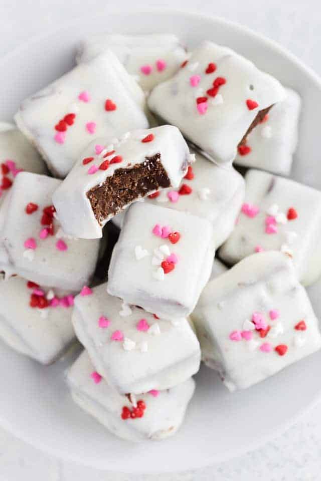 Mexican hot chocolate fudge coated in white chocolate stacked on a white plate.