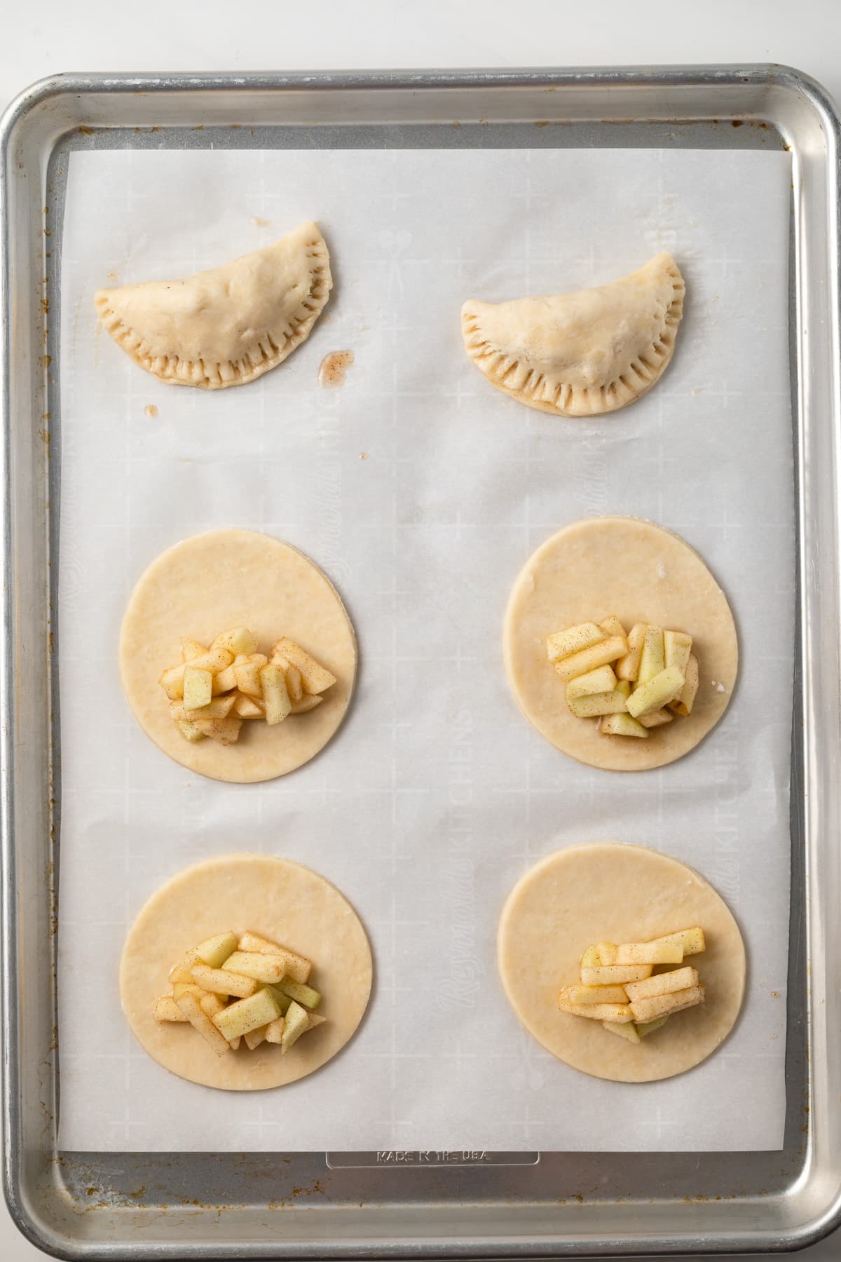 Filling over pie dough circles on a baking sheets.