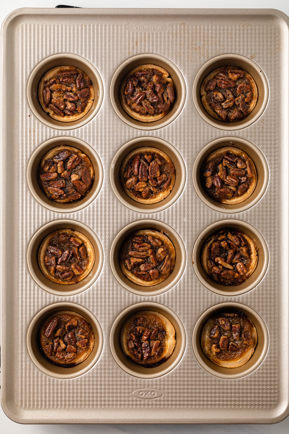 Mini pecan pies in a muffin pan.
